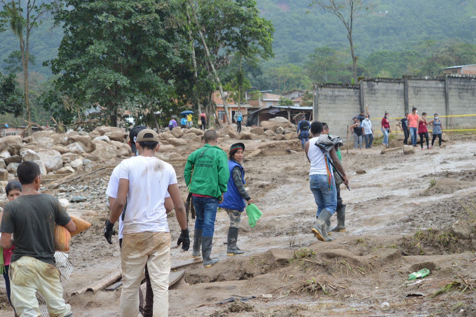 Volunteers and responders working through mud after a landslide