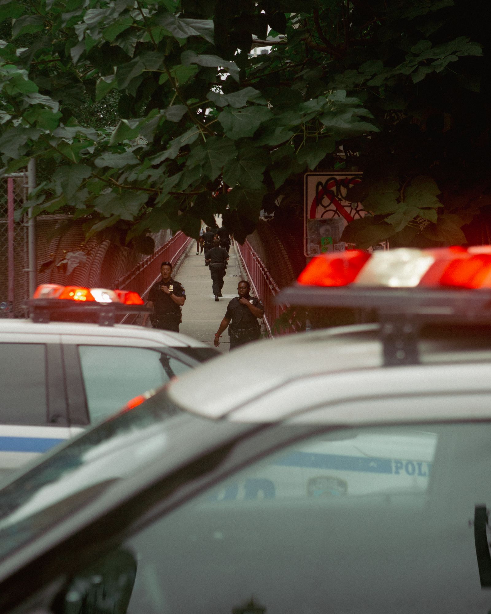 Police officers walking a patrol route past parked cruisers